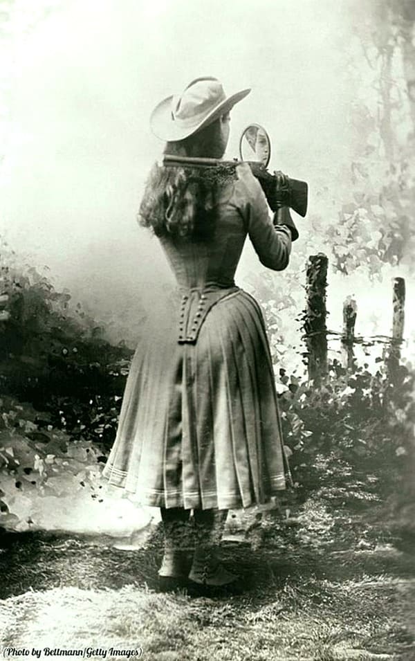Снайпер Энни Окли стреляет через плечо с помощью ручного зеркала, около 1899 года .