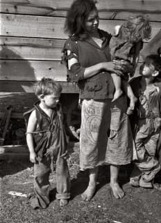 
Мать и ребенок из семьи из девяти человек, живущих в поле на шоссе 70 США в Теннесси, недалеко от реки Теннесси